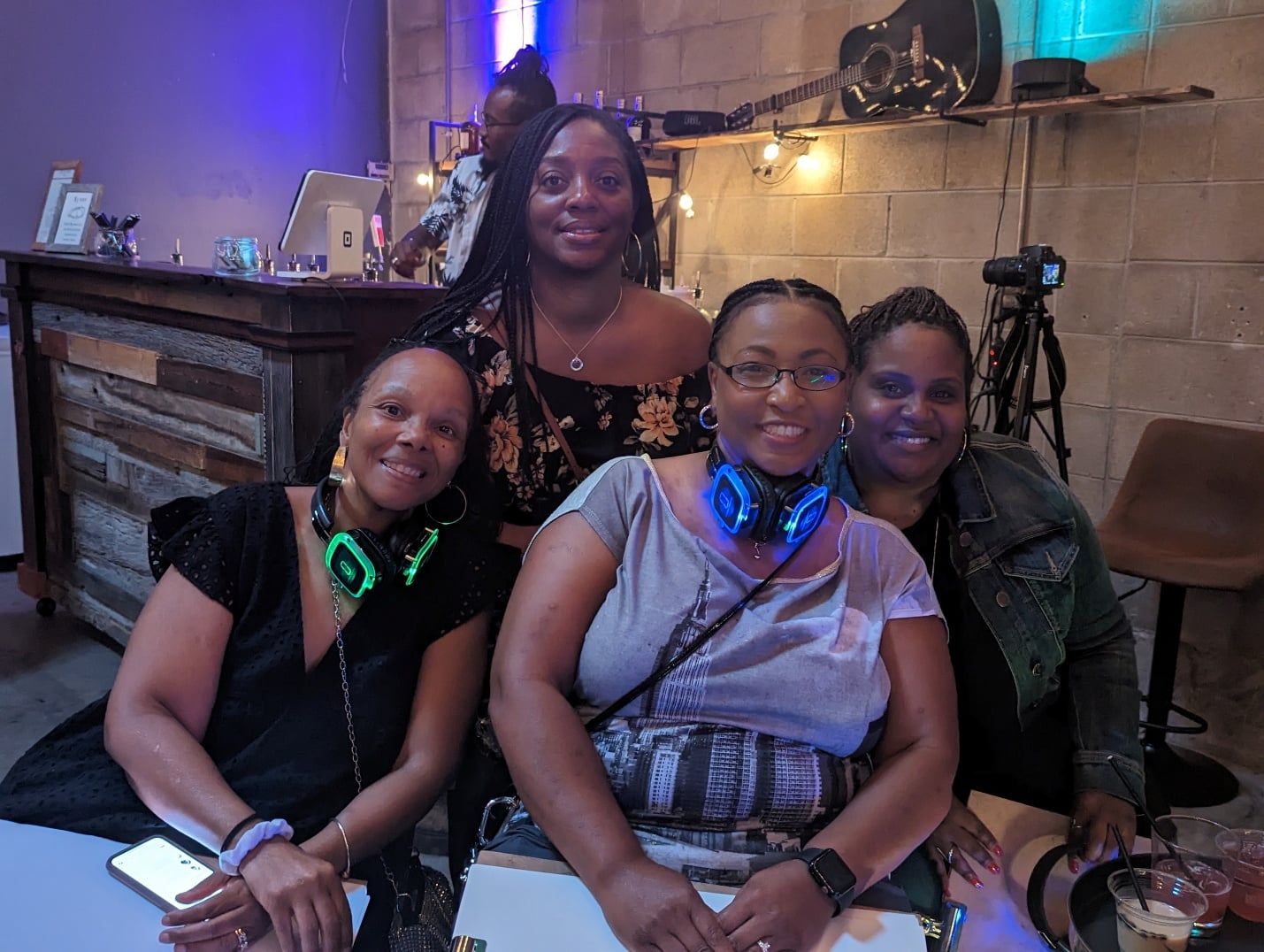 Group of friends with glowing LED silent disco headphones around their necks at a Sketch & Sip event