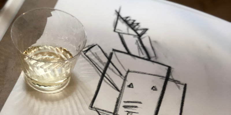A finished pencil sketch next to a drink at a CiferNoise Sketch & Sip event