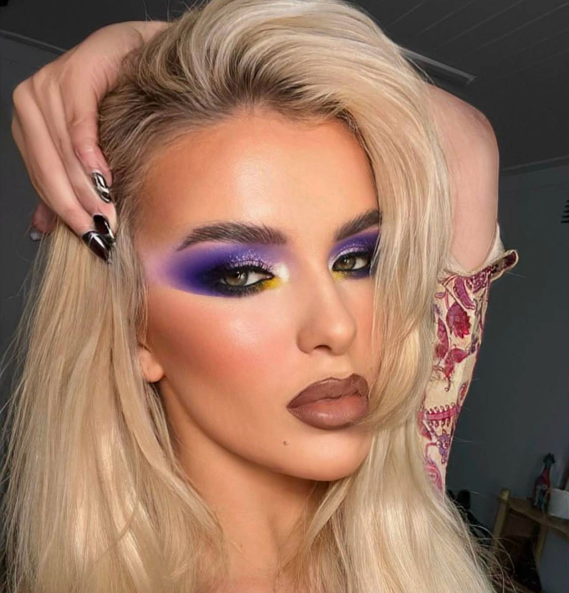 Purple and yellow cut crease with a glossy nude lip
